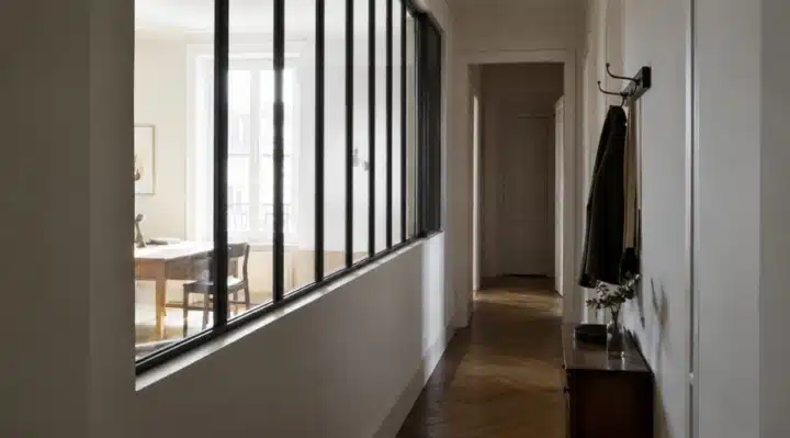 Verrière intérieure installée dans une entrée d'appartement pour apporter de la luminosité au couloir