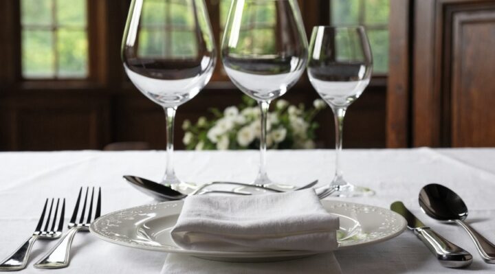 Dresser une table à la française : fourchettes à gauche, couteau et cuillère à droite, serviette pliée sur l'assiette